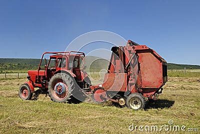 Red tractor and hay baler