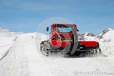 Red tractor on snow slope