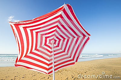 Red and white sunshade flying away