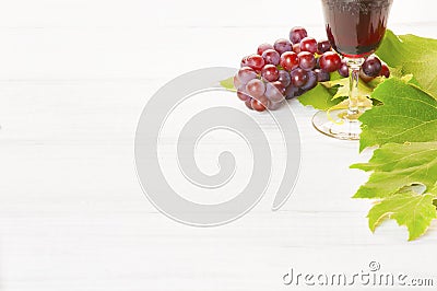 Red Wine and Grapes with Leaves on white wood background, a horizontal with room or space for your words, text or copy