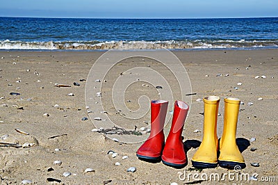 Red and yellow rain boots on the beach