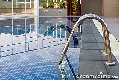 Reflection of water,Swimming pool with steel ladderbar.