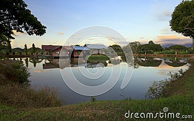 Reflection of a wooden house on a lake at sunset in Sabah, Borneo