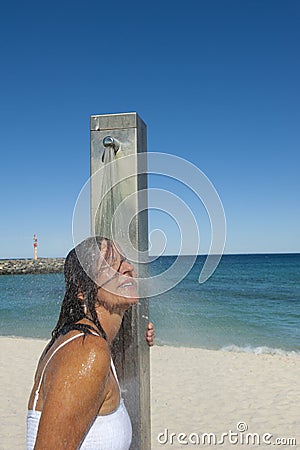 Refreshing shower for sexy woman at the ocean