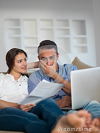 Relaxed young couple working on laptop computer at home