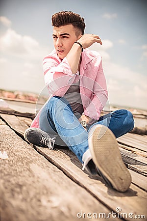 Relaxed young fashion man sitting outdoor