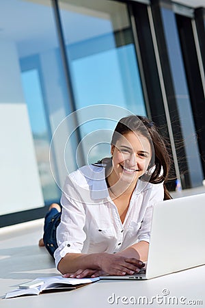 Relaxed young woman at home working on laptop computer