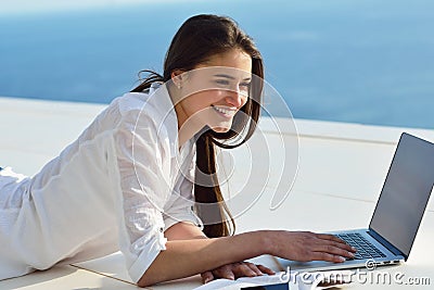 Relaxed young woman at home working on laptop computer