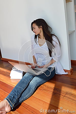 Relaxed young woman at home working on laptop computer