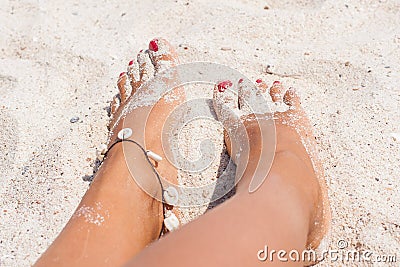 Relaxing at a beach, with your feet on the sand.