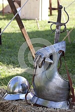 Renaissance weapons and armors in the grass lawn.