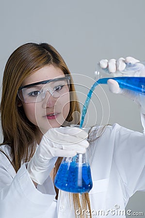 Research assistant pouring chemicals in the Lab