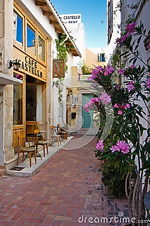Restaurant in shade at the street of old medieval city and harbor Rethymno, Crete