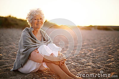 Retired woman sitting on the beach