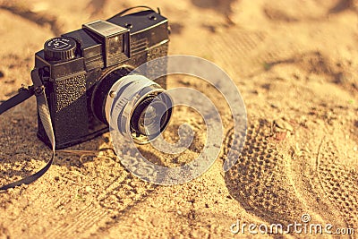 Retro camera on sand