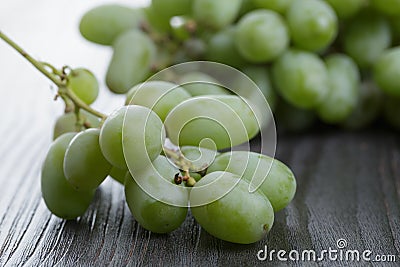 Ripe green grapes on black wood table