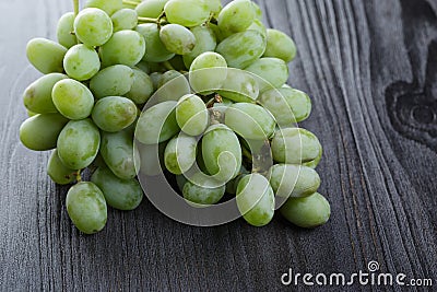 Ripe green grapes on black wood table