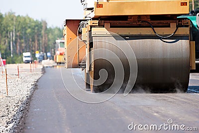 Road roller compacting asphalt pavement