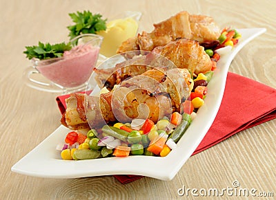 Roast chicken leg wrapped in bacon with vegetables