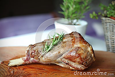 Roasted leg of lamb with rosemary on the cutting b