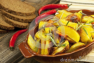 Roasted potato in bowl on wooden table