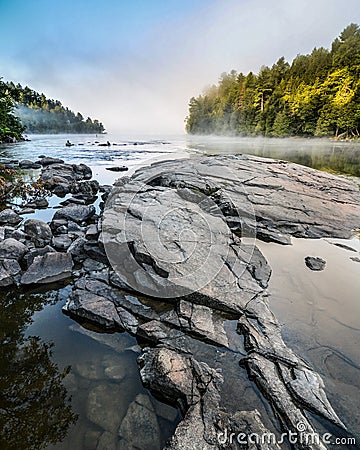 Rocks in a river at sunrise in the mist
