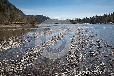 Rocks on the shore of a mountain river, the shallow of the river