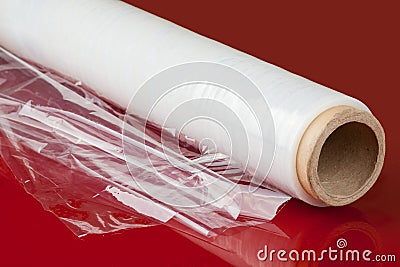 A roll of packaging film on a red background