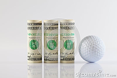 Rolls of dollar bills and golff ball