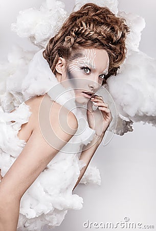 Romantic beauty with magnificent hair wandering in clouds. Studio fashion portrait.