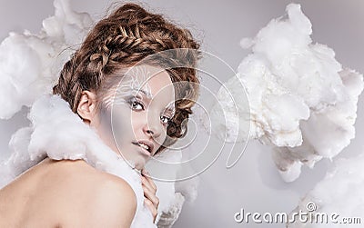 Romantic beauty with magnificent hair wandering in clouds. Studio fashion portrait.