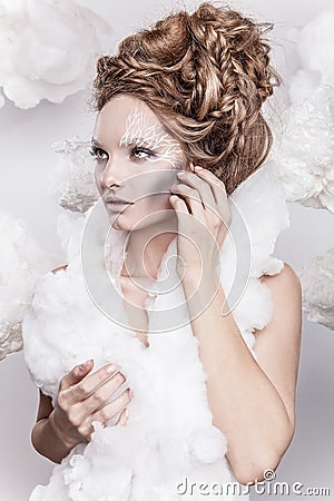 Romantic beauty with magnificent hair wandering in clouds. Studio fashion portrait.