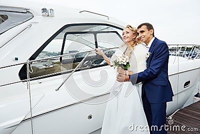 Romantic bride and groom on the pier with yacht