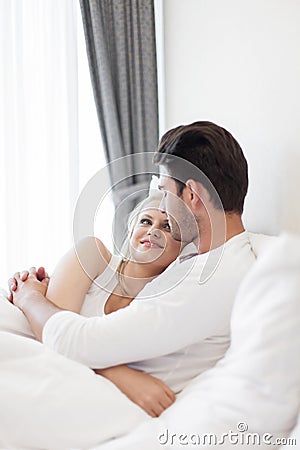 Romantic young couple embracing in bed