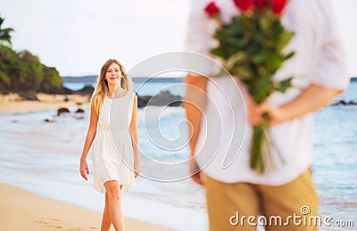 Romantic Young Couple in Love, Man holding surprise bouquet of r