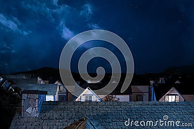 Roof of house at night with houses on background