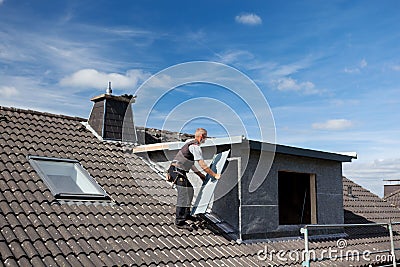 Roofer carrying a metal piece to the dormer