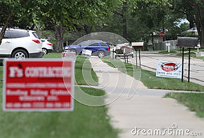 Roofing signs on neighborhood street following hail damage