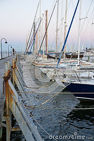 Row of boats tied to a pier at sunset