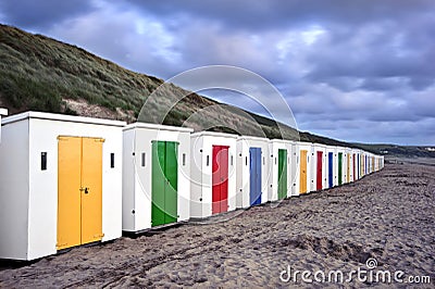 Row of colorful beach huts on empty beach
