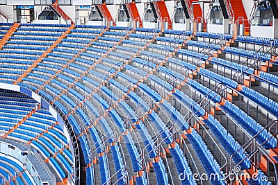 Rows of blue grandstand for fans at football stadium.