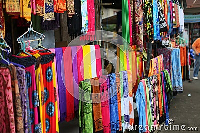 Rows of colourful silk scarfs hanging at a market stall in Indon