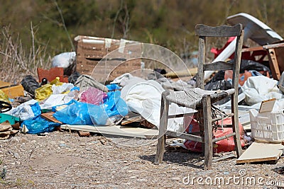 Rubbish dumped at side of road with chair.