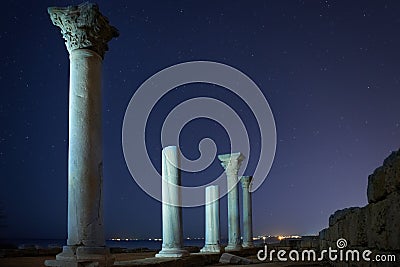 Ruins of ancient city columns under night sky