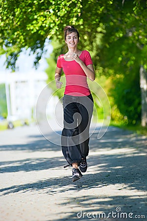 Runner - woman running outdoors in green park