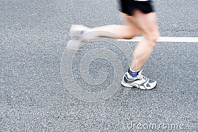 Running marathon on city street, motion blur