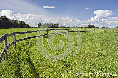 Rural landscape farmland field with wooden fence
