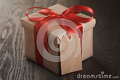 Rustic gift box with red ribbon bow and emmpty tag