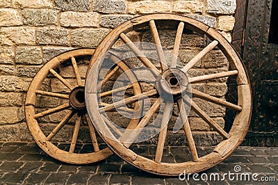 Rustic wagon wheels in front of the wall in old city Baku Azerbaijan