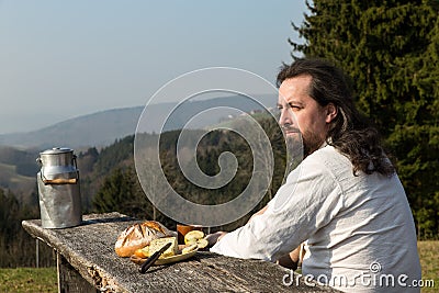 Rustically long-haired man is snacking healthy food